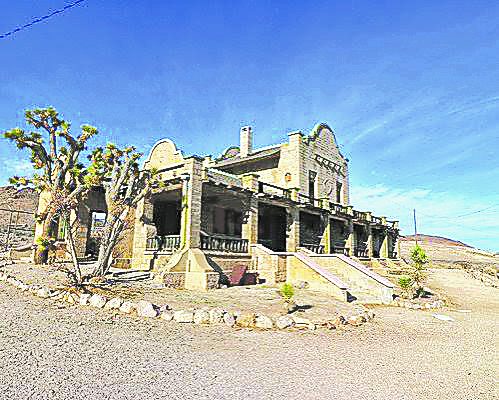 The stone ruins of the historic Rhyolite railroad depot standing in the desert near Joshua trees