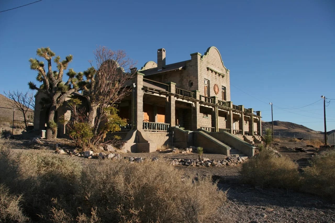 The stone ruins of the Las Vegas and Tonopah Railroad depot at Rhyolite, the ghost town outside Beatty, Nevada, framed by Joshua trees